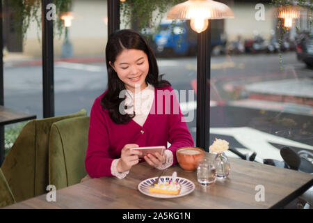 Frau fotografieren Torte im Café Stockfoto