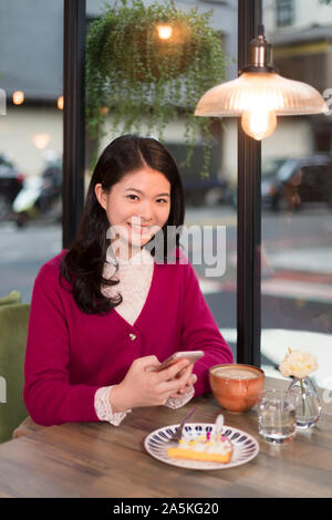 Frau fotografieren Torte im Café Stockfoto