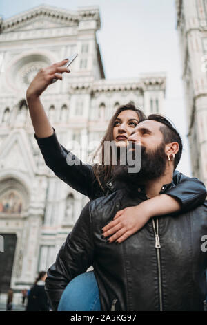 Paar spielen piggyback Ride und unter selfie, Santa Maria del Fiore, Firenze, Toscana, Italien Stockfoto