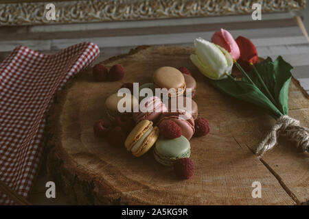 Macarons verschiedener Aromen mit Himbeeren auf hölzernen Cookie Stockfoto