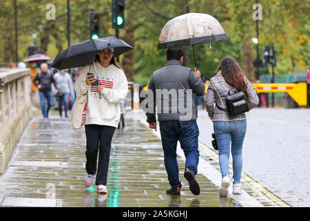 London, Großbritannien. Okt, 2019 21. Touristen sind zu sehen, die dem Schutz vor dem Regen unter Sonnenschirmen an einem regnerischen Tag in London. Quelle: Steve Taylor/SOPA Images/ZUMA Draht/Alamy leben Nachrichten Stockfoto