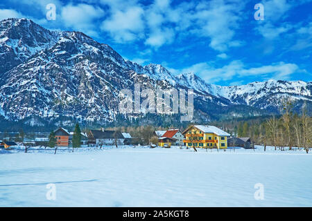 Den Winter morgen in Bad Goisern mit Blick auf verschneite Wiese, Leitung von Häusern und großen Dachstein im Hintergrund, Salzkammergut, Österreich Stockfoto