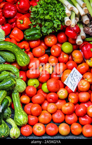 Frisches Gemüse auf dem Bauernmarkt. Handschriftlichen Papier auf Portugiesisch mit Namen der pflanzlichen Art und Preis. Ökologische Lebensmittel. Rote Tomaten, grüne Zucchini, rote Paprika, Lauch. Vegetarisch kochen. Stockfoto