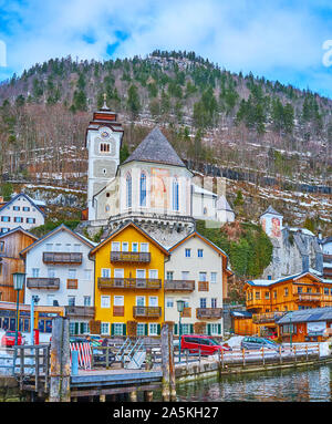 HALLSTATT, Österreich - Februar 25, 2019: Der Blick auf die Stadt von der Bank von hallstattersee See, die Kirche der Hl. Maria am Berg über die Häuser steigt, o Stockfoto