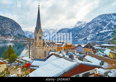 Beobachten Sie die spiegelfläche von hallstattersee See, felsigen Dachstein Alpen und hohen Kirchturm der Pfarrkirche über die Altstadt Dächer, Hallstatt, Salzkammergu Stockfoto