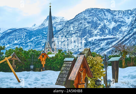 HALLSTATT, Österreich - 25. FEBRUAR 2019: Die verschneite Friedhof der Pfarrkirche Maria am Berg mit Blick auf hohen Turm der Evangelischen Kirche und Dachste Stockfoto