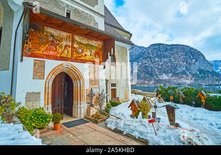 HALLSTATT, Österreich - 25. Februar 2019: Der Eingang zum neugotischen Maria am Berg Pfarrkirche mit erhaltenen mittelalterlichen Fresken über die gewölbten Tür, auf Stockfoto