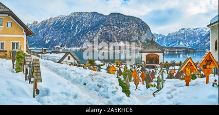 HALLSTATT, Österreich - Februar 25, 2019: Winter Panorama der Friedhof von Maria am Berg Pfarrkirche mit Holzkreuzen, gekrönt mit Dächern und surr Stockfoto