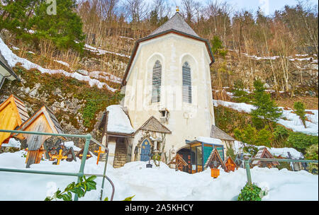 HALLSTATT, Österreich - 25. Februar 2019: Der Blick auf den Friedhof von Maria am Berg Pfarrkirche und Beinhaus Beinhaus, umgeben von Wald auf Salzber Stockfoto