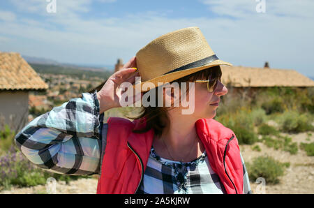 Attraktives Mädchen Tourist in einen Hut steht auf der Strasse einer kleinen Siedlung Stockfoto