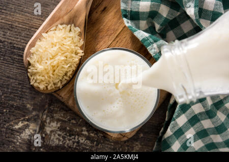 Preis Milch in Glas auf hölzernen Tisch. Ansicht von oben Stockfoto