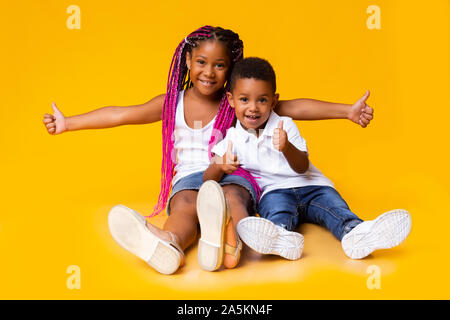 Adorable kleine schwarze Schwester und Bruder, Daumen hoch Stockfoto