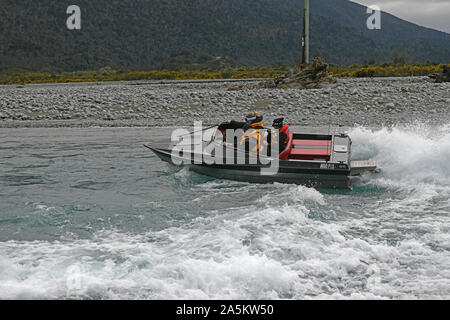 TARAMAKAU FLUSS, WEST COAST, NEUSEELAND, September 3, 2019: Drei Leute an die Macht ihrer Jetboot, das Taramakau Fluss Stockfoto