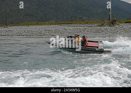 TARAMAKAU FLUSS, WEST COAST, NEUSEELAND, September 3, 2019: Drei Leute an die Macht ihrer Jetboot, das Taramakau Fluss Stockfoto