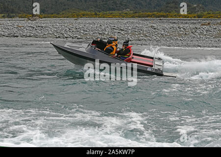 TARAMAKAU FLUSS, WEST COAST, NEUSEELAND, September 3, 2019: Drei Leute an die Macht ihrer Jetboot, das Taramakau Fluss Stockfoto