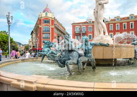 Touristen vorbei an den Brunnen der Sonne mit römischen Gott Apollo an der Place Massena in der mediterranen Stadt Nizza, Frankreich. Stockfoto