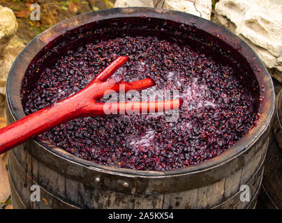 Rotwein in Prozess. Funktioniert das Mischen von Wein in den Prozess der Gärung. Stockfoto