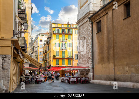 Touristen genießen eine lebhafte am späten Nachmittag in den Geschäften und Cafés in Place Rossetti, in der Altstadt von Nizza, Frankreich, an der Französischen Riviera. Stockfoto