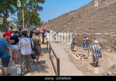 Gruppe von Touristen neben einem Tableau zeigt eine Ychsma Beerdigung Ritual, Huaca Pucllana, Miraflores, Lima, Peru, Südamerika Stockfoto