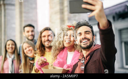 Gruppe der multirassischen Freunde essen Asiatische Street Food und unter selfie Outdoor - junge trendige Leute Spaß mit neuen mobilen Smartphone Apps Stockfoto