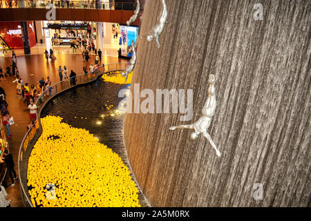 Dubai/VAE - Oktober 19, 2019: Der Wasserfall in der Dubai Mall mit Masse, weltweit größte Shopping Mall. Menge in der Dubai Mall, Ansicht von oben. Stockfoto