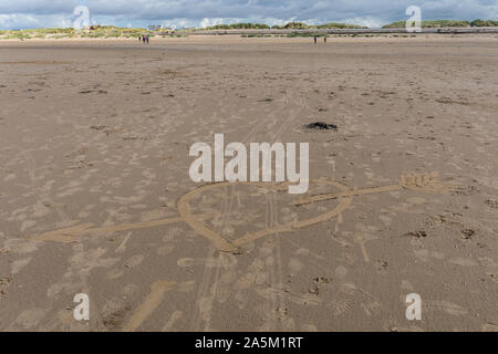 Herz mit einem Pfeil, der in den Sand am Crosby Beach in der Nähe von Liverpool, Merseyside, Großbritannien gezeichnet Stockfoto