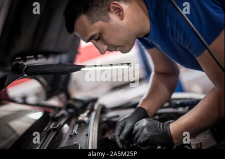 Auto master Automechaniker Werkstatt Service Techniker überprüft und Reparaturen den Motor Zustand unter der Motorhaube des Fahrzeugs Service Shop Stockfoto