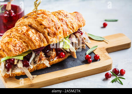 Croissant Sandwich mit Entenfleisch, Frischkäse und preiselbeersoße an Bord, weißen Hintergrund. Stockfoto