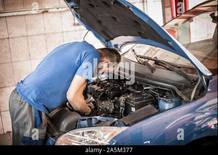 Auto master Automechaniker Werkstatt Service Techniker überprüft und Reparaturen den Motor Zustand unter der Motorhaube des Fahrzeugs Service Shop Stockfoto