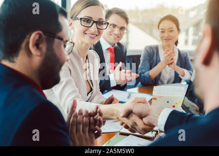 Team von Geschäftsleuten, das die Aushandlung eines Abkommens Schließen des Abkommens Stockfoto