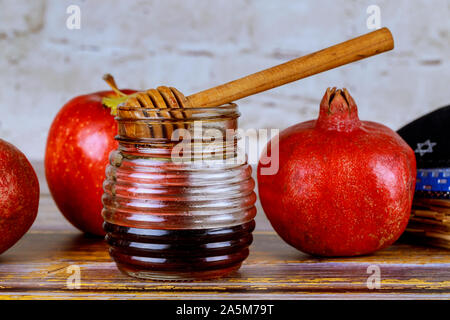 Gießen Honig auf Apple und Granatapfel Honig mit Symbolen der Jüdischen Neujahrsfest Rosh Hashana. Stockfoto