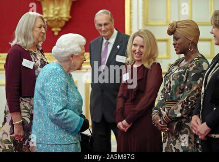 Königin Elizabeth II. treffen Freiwilliger, einschließlich Yolande Clarke (rechts) aus Manchester, und Jo Smyth (2. rechts) aus Cambridge bei einem Empfang zum 60. Jahrestag der Wasserbecher Trauerfall Pflege im St James's Palace in London zu markieren. Stockfoto