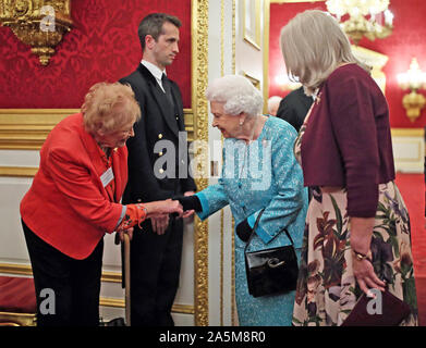 Königin Elizabeth II. treffen Freiwillige bei einem Empfang zum 60. Jahrestag der Wasserbecher Trauerfall Pflege im St James's Palace in London zu markieren. Stockfoto