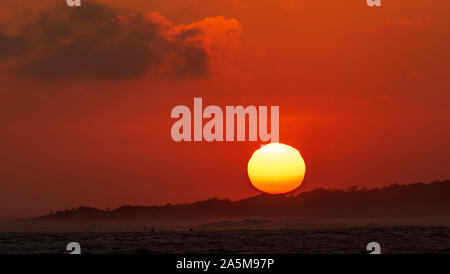 Nahaufnahme von den Sonnenuntergang sunball als taucht hinter dem Strand Kopf in der Nähe des Surf spot Unteren Gerüste in San Clemente, Südkalifornien. Stockfoto