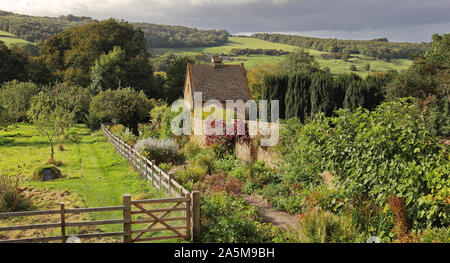 Cotswold Hills Landschaft mit ummauerten Garten im Vordergrund. Stockfoto