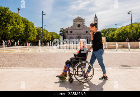 Frau drücken Mutter auf Rollstuhl, Piazza Risorgimento, Avezzano, Abruzzen, Italien Stockfoto
