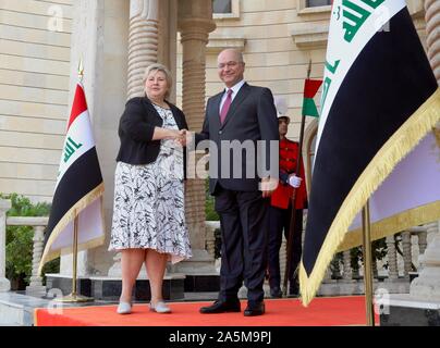 (191021) - Bagdad, Oktober 21, 2019 (Xinhua) - der Irakische Barham Salih (R, vorne) schüttelt Hände mit norwegischen Premierminister Erna Solberg in Bagdad, Irak, am Okt. 21, 2019. Der Ministerpräsident von Norwegen Erna Solberg kam in der irakischen Hauptstadt Bagdad am Montag mit irakischen Beamten über Stärkung der bilateralen Beziehungen und regionale Fragen zu treffen. (Xinhua / Khalil Dawood) Stockfoto