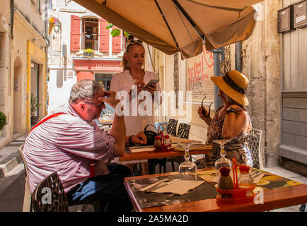 Kellnerin das Essen Aufträge von Kunden im Cafe, Arles, Frankreich Stockfoto
