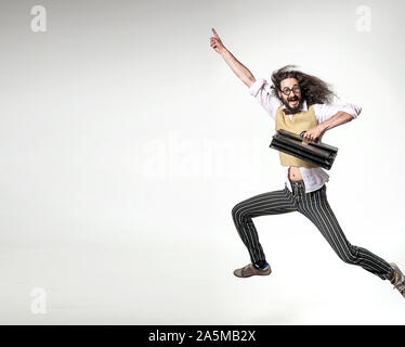 Nerdy Mann mit einer Aktentasche und springen über der Tafel im Hintergrund Stockfoto