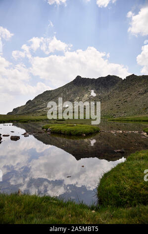 Laguna de Los Pájaros Gletschersee und Risco de Los Claveles Peak auf der Rückseite im Naturpark Peñalara (Guadarrama Nationalpark, Madrid, Spanien) Stockfoto