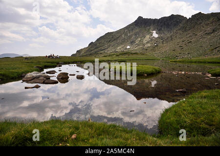 Laguna de Los Pájaros Gletschersee und Risco de Los Claveles Peak auf der Rückseite im Naturpark Peñalara (Guadarrama Nationalpark, Madrid, Spanien) Stockfoto