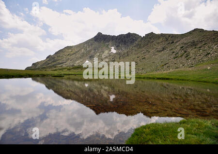 Laguna de Los Pájaros Gletschersee und Risco de Los Claveles Peak auf der Rückseite im Naturpark Peñalara (Guadarrama Nationalpark, Madrid, Spanien) Stockfoto