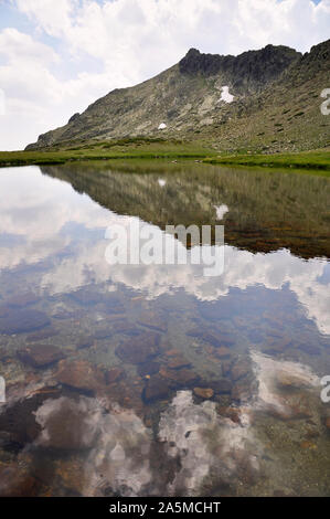 Laguna de Los Pájaros Gletschersee und Risco de Los Claveles Peak auf der Rückseite im Naturpark Peñalara (Guadarrama Nationalpark, Madrid, Spanien) Stockfoto