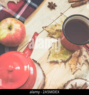 Heißen Tee, warme Decke, Apple, Zimtstangen, Sternanis Star und Blätter im Herbst auf alten Holz- Hintergrund, Vintage Farben Foto. Ansicht von oben, flach. Stockfoto