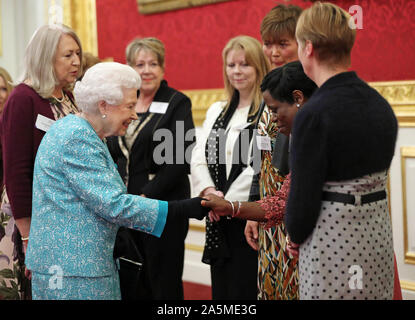 Neu enthalten zusätzliche Informationen Queen Elizabeth II Konferenz Nicola Dias, die umfangreiche Unterstützung auf der Grenfell Turm Feuer und anderen Freiwilligen bei einem Empfang zum 60. Jahrestag der Wasserbecher Trauerfall Pflege im St James's Palace in London zu Zeichen übertragen. Stockfoto