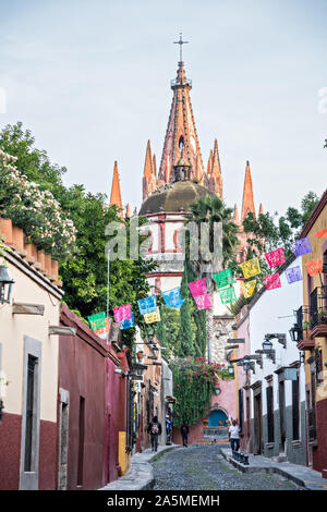 Kuppeln und Turmspitzen der Parroquia San Miguel Arcangel Kirche durch Papier Banner genannt Papel picado auf Aldama Straße im historischen Bezirk von San Miguel de Allende, Mexiko gesehen. Stockfoto