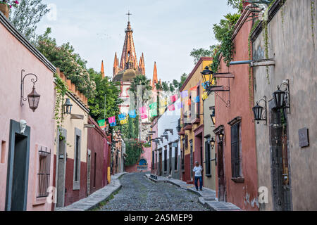 Kuppeln und Turmspitzen der Parroquia San Miguel Arcangel Kirche durch Papier Banner genannt Papel picado auf Aldama Straße im historischen Bezirk von San Miguel de Allende, Mexiko gesehen. Stockfoto