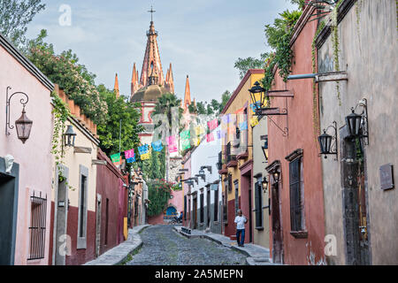 Kuppeln und Turmspitzen der Parroquia San Miguel Arcangel Kirche durch Papier Banner genannt Papel picado auf Aldama Straße im historischen Bezirk von San Miguel de Allende, Mexiko gesehen. Stockfoto