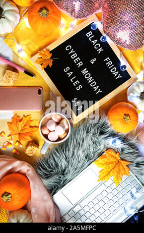 Vorbereitung für Schwarzer Freitag und Cyber Monday shopping hygge Stil Thanksgiving Wochenende Konzept mit heißer Schokolade im Bett mit Smartphone und Laptop. Stockfoto