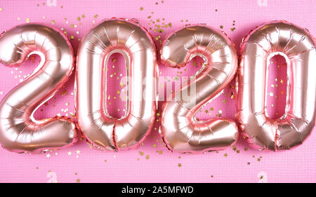 Happy New Year's Eve Rose Gold Folie 2020 metallic Ballons auf moderne rosa Hintergrund, mit goldfarbenem Glitter Sterne schließen. Stockfoto